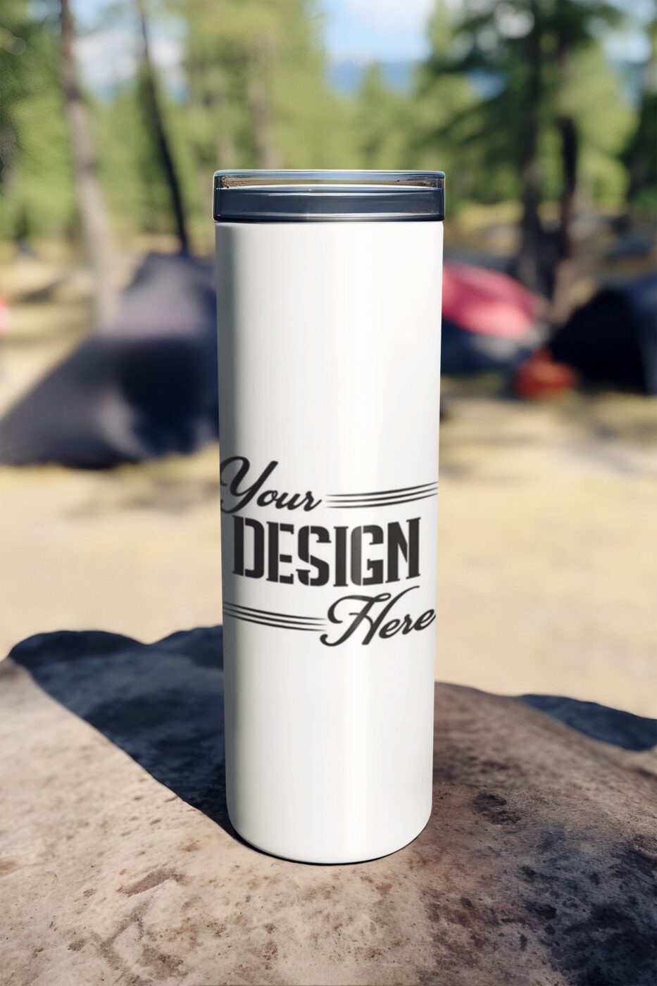 A tall white insulated tumbler standing on a rock outdoors, printed with the words Your Design Here.